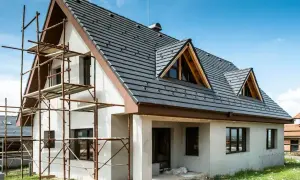 Dom w trakcie budowy, rusztowania przy ścianie. Zastanawiasz się, ile kosztuje ocieplenie domu 200m2?