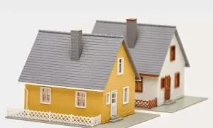 Dwa domki modelowe. Jeden żółty, drugi biały. Budowa domu w granicy działki wymaga zgody sąsiada.