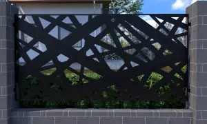 Czarna, ażurowa metalowa przegroda z geometrycznym wzorem, osadzona między kamiennymi słupkami.