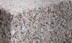 Materiały budowlane: celuloza ocieplenie z recyklingu, tworzące zwartą, włóknistą strukturę z kolorowymi fragmentami.