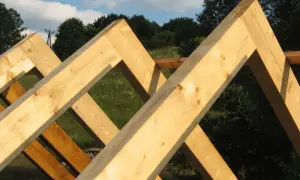 Drewniane krokwie tworzą konstrukcję dachu, ukazując staranne łączenie krokwi w szczycie.