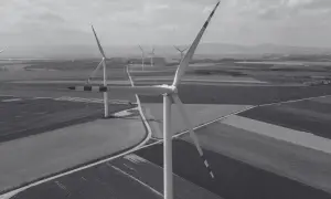 Wiatraki na tle pól i wzgórz. Nowa ustawa wiatrakowa sprzyja rozwojowi farm wiatrowych, tworząc zieloną energię.