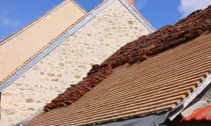 Remont dachu wymaga pozwolenia na budowę? Na zdjęciu widać dach w trakcie prac, z nowymi łatami i starymi dachówkami.