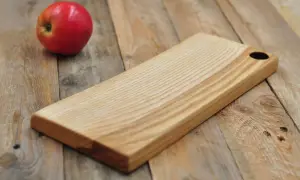 Deska do krojenia z naturalnego jesionu, gotowa na przyjęcie świeżego jabłka.