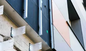 System mocowania elewacji wentylowanej z widocznymi wspornikami aluminiowymi i czarną membraną. Nowoczesne wykończenie budynku.