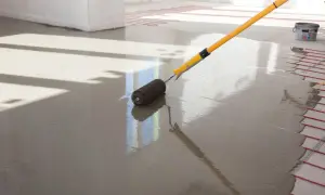 Wałek do betonu wygładza świeżą anhydryt posadzka z ogrzewaniem podłogowym.