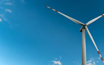 Wiatrak na tle błękitnego nieba, symbol czystej energii wiatru.