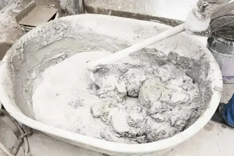 Mieszanie wapna gaszonego w dużej kadzi, tworząc gładką masę do prac budowlanych.