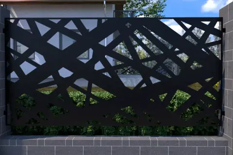 Czarna, ażurowa metalowa przegroda z geometrycznym wzorem, osadzona między kamiennymi słupkami.