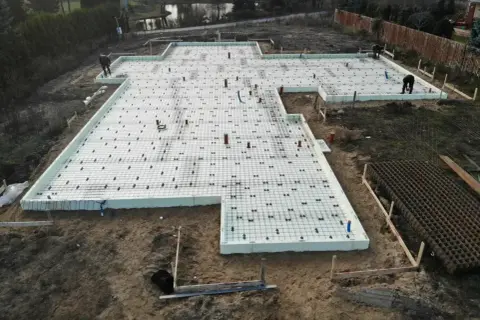 Budowa fundamentów pod dom. Widać zbrojenie i styropian, przygotowane pod szybki beton.
