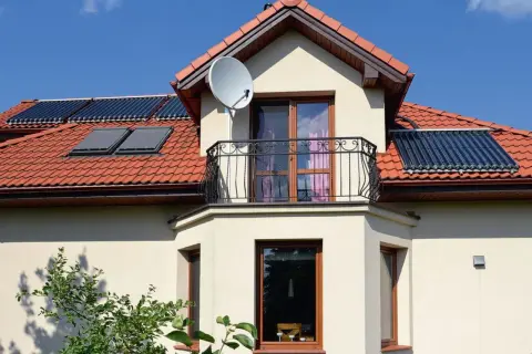 Nowoczesny wykusz w domu z balkonem i kolektorami słonecznymi na dachu.