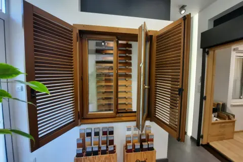 Drewniane okno z żaluzjami i próbkami kolorów w salonie okien i drzwi.