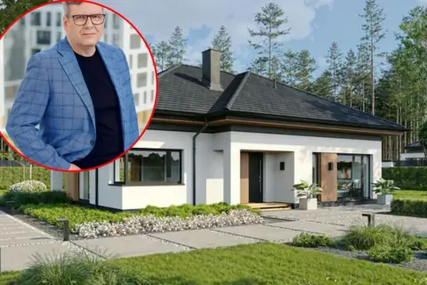 Mężczyzna w garniturze obok nowoczesnego domu. Wizualizacja koszt budowy domu 220m2.