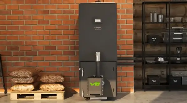 Nowoczesny piec na pellet z zielonym logo, obok palety z workami pelletu. Dofinansowanie do pieca na pellet może być Twoje!