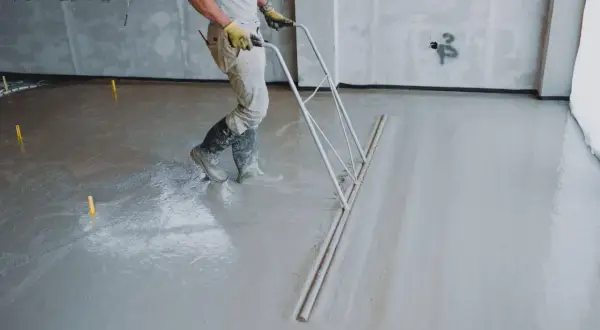 Robotnik zacierający świeży miksokret na budowie.
