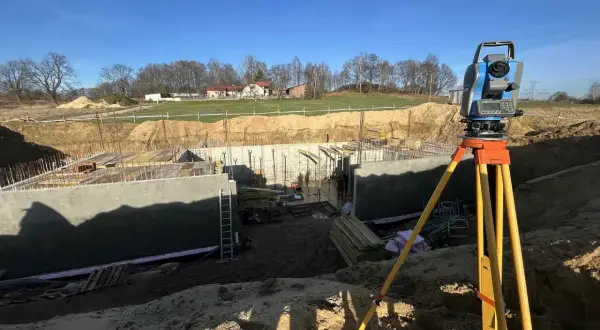 Precyzyjne pomiary na budowie. Geodeta ustawia tachimetr, by dokładnie określić położenie elementów fundamentów.
