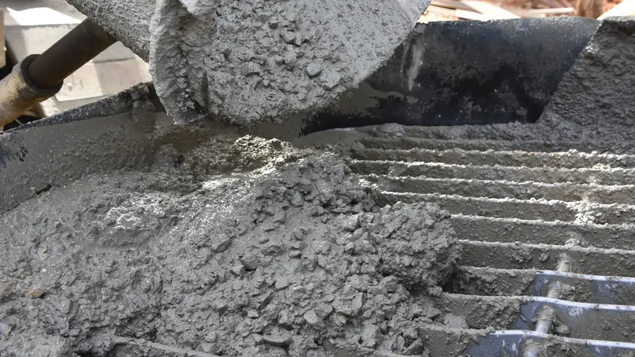 Świeży beton z kruszywem, idealny jako jaki beton pod obrzeża, wylewany na ruszt.