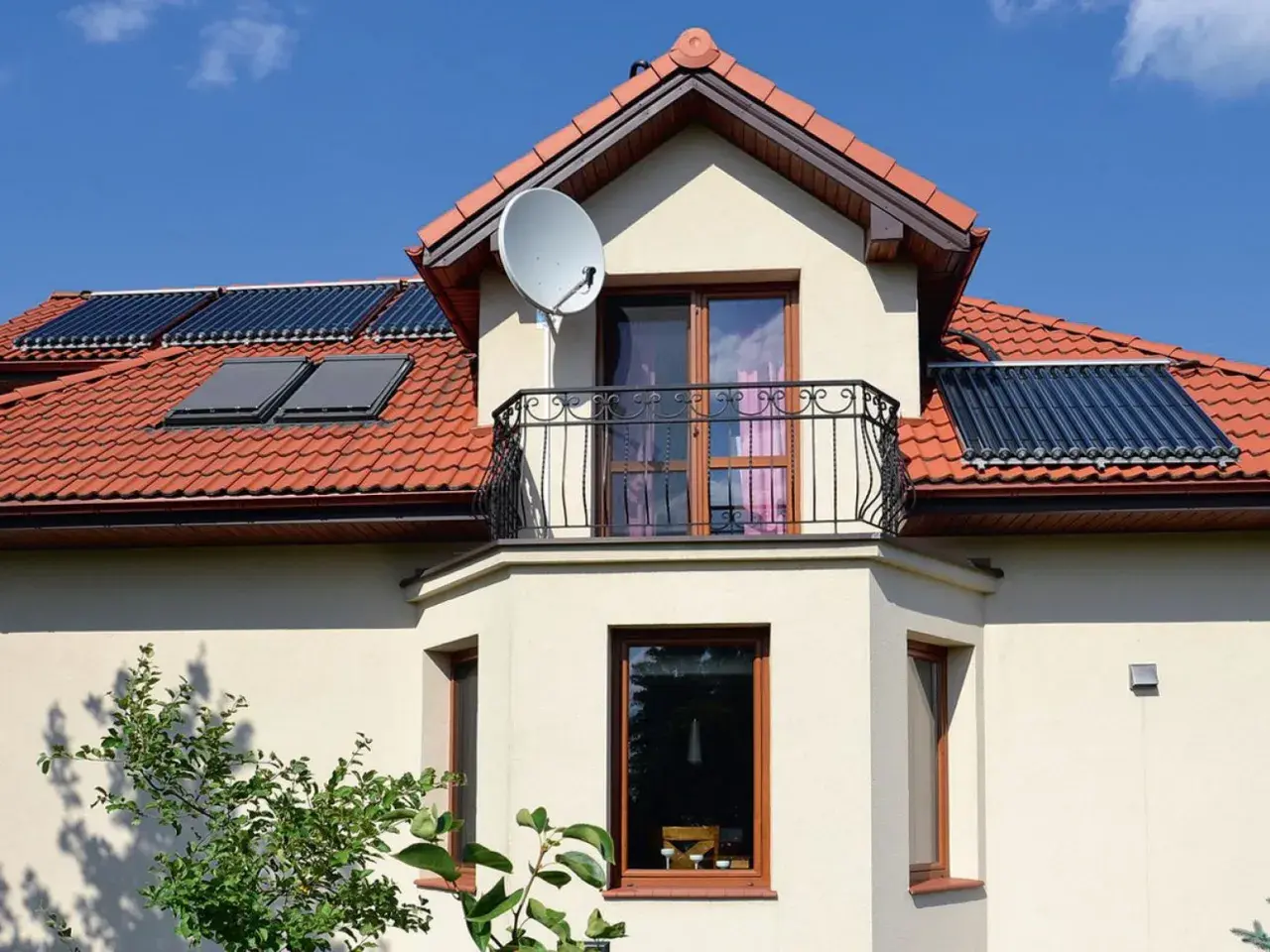 Nowoczesny wykusz w domu z balkonem i kolektorami słonecznymi na dachu.