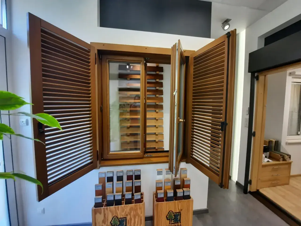 Drewniane okno z żaluzjami i próbkami kolorów w salonie okien i drzwi.