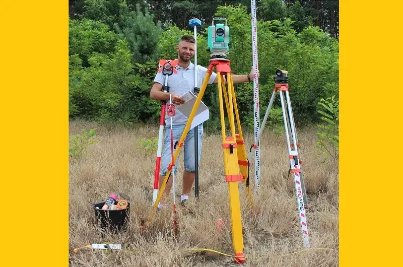 Geodeta z tachimetrem na budowie, pomiar punktów geodezyjnych