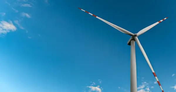 Wiatrak na tle błękitnego nieba, symbol czystej energii wiatru.