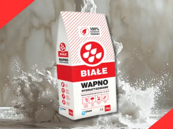 Białe wapno hydratyzowane w worku, otoczone chmurą pyłu. Idealne do budowy i tynkowania.
