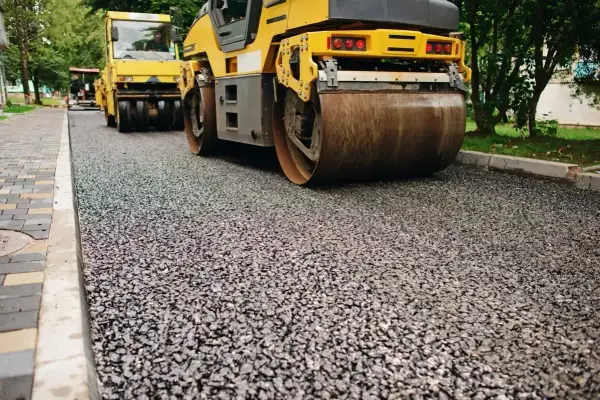 Walec drogowy ugniata świeżą nawierzchnię z kruszywa dolomitowego.